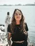 woman in black crew neck t-shirt wearing brown framed eyeglasses standing on rocky shore during