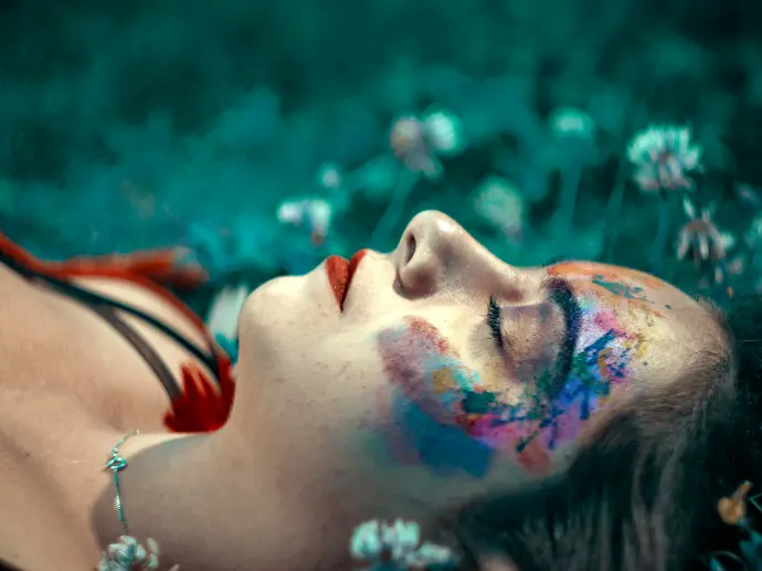 tilt shift lens photography of woman laying on green grass